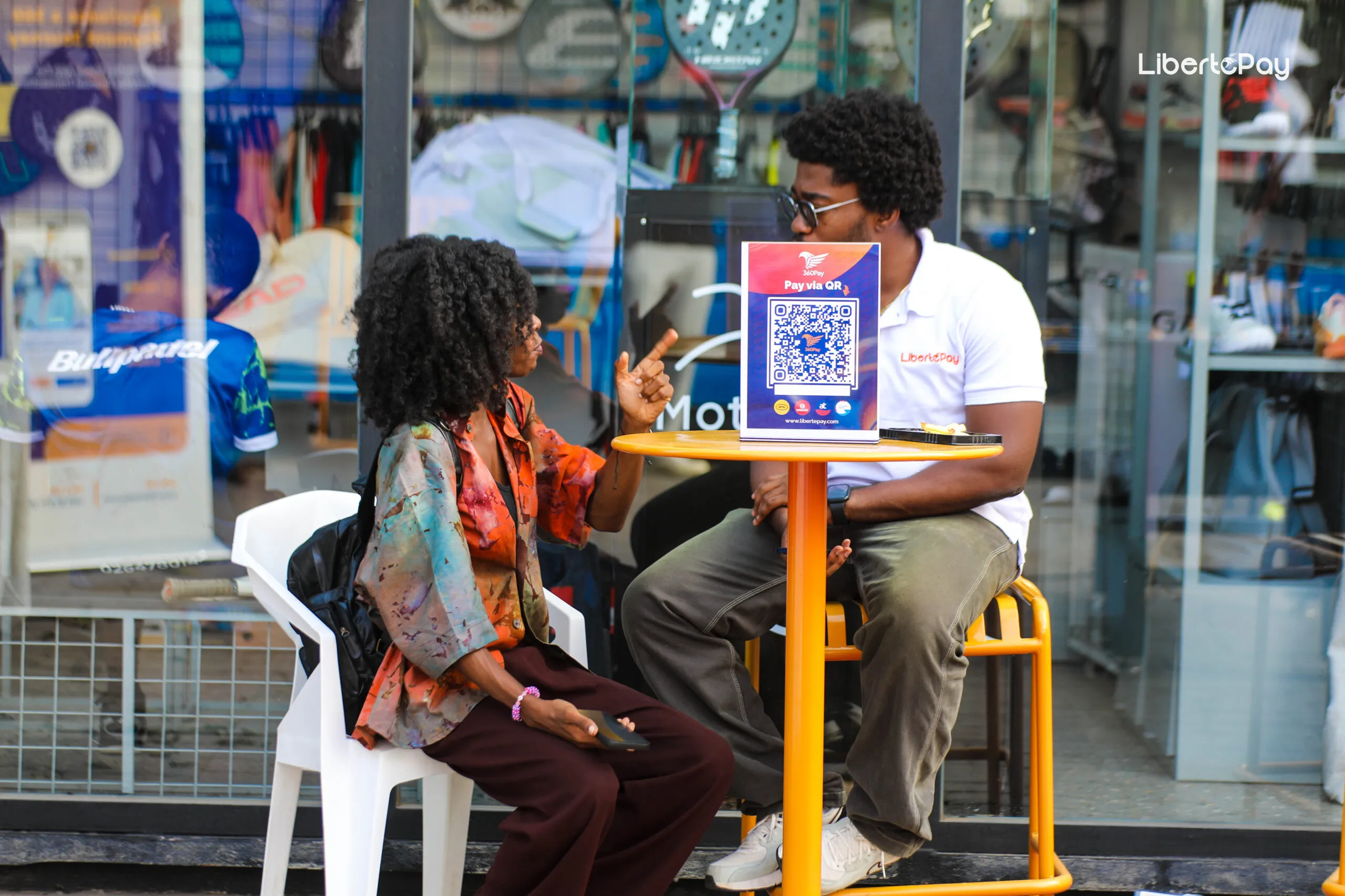 LibertéPay representative discussing a QR payment with a customer